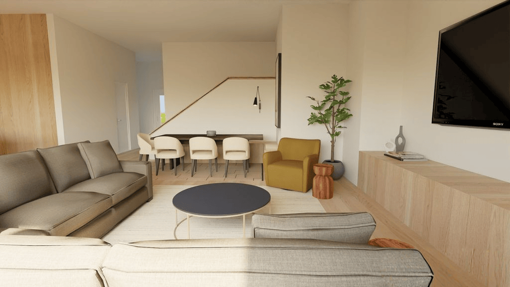 A modern living room featuring a large gray sofa, a yellow armchair, a round coffee table, and a plant. In the background, a dining area with a wooden table and light-colored chairs, along with a wall-mounted TV.